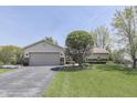 Beautiful ranch home with a two-car garage, well-manicured lawn, and lovely landscaping at 407 N Matthews Rd, Greenwood, IN 46143
