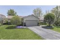 Inviting home with attached two-car garage, pretty landscaping, and a well-kept lawn at 407 N Matthews Rd, Greenwood, IN 46143