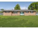 Charming brick home with a well-maintained lawn, black shutters, and a cheerful blue front door at 4126 S Gerrard Dr, Indianapolis, IN 46221