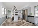 Open kitchen with stainless steel appliances, an island, and elegant gray cabinets at 4126 S Gerrard Dr, Indianapolis, IN 46221