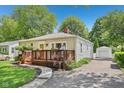Quaint home with a well-kept lawn, wooden deck, and a detached garage visible down the driveway at 5333 Ralston Ave, Indianapolis, IN 46220