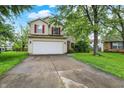 Charming two-story home with red shutters, attached two car garage, and a well maintained lawn at 5369 Red River Ct, Indianapolis, IN 46221