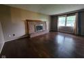 Cozy living room with a brick fireplace, hardwood floors, and natural light at 5515 Lunsford Dr, Indianapolis, IN 46237