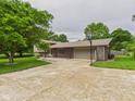 Lovely home with a long driveway and a basketball hoop, framed by lush greenery and mature trees at 5542 N Olivia Dr, Alexandria, IN 46001
