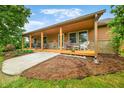 Inviting exterior showcasing a covered porch with outdoor seating and professionally landscaped yard at 5730 S 50 W, Trafalgar, IN 46181