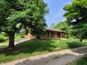 Home with a covered porch overlooking a serene and green landscape, with a gravel path at 5730 S 50 W, Trafalgar, IN 46181