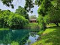 Beautiful pond reflecting a lovely home nestled among lush trees and greenery at 5730 S 50 W, Trafalgar, IN 46181