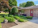 Charming ranch home featuring lush landscaping and a brick pathway at 5730 Teresa Dr, Alexandria, IN 46001