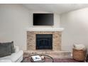 Close-up of the brick fireplace, complete with a mantel and decorative items at 5873 N Victoria Dr, Indianapolis, IN 46228