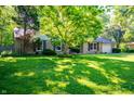 Well-manicured lawn and landscaping complement this charming single-story brick home at 5873 N Victoria Dr, Indianapolis, IN 46228
