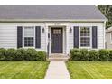 Close-up showcasing the front door, black shutters and lush green bushes at 6040 Crittenden Ave, Indianapolis, IN 46220