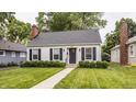 Classic home with black shutters, a brick chimney, and a well-kept lawn enhancing its appeal at 6040 Crittenden Ave, Indianapolis, IN 46220