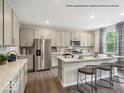 Modern kitchen with stainless steel appliances, an island with seating, and sleek gray cabinets at 6049 Madera Dr, Whitestown, IN 46075