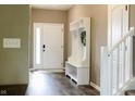 Welcoming entryway with wood floors, white storage bench, and a view of the staircase at 6377 Harvey Dr, Plainfield, IN 46168