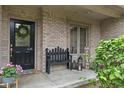 Welcoming front porch featuring a black door, bench, and charming seasonal decor at 7141 Ember Ct, Indianapolis, IN 46236