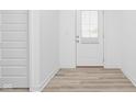 Inviting entryway with wood-look flooring, a white door with glass, and crisp, white walls at 7431 Stillness Dr, Indianapolis, IN 46268