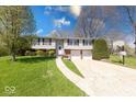 Well-kept two-story home boasts a pristine lawn, mature trees, and a spacious driveway with a basketball hoop at 8120 Trevellian Way, Indianapolis, IN 46217