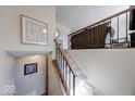 Inviting staircase with plush carpeting and wood railing leads to the upper level at 8120 Trevellian Way, Indianapolis, IN 46217
