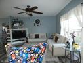 A modern living room featuring couches, a ceiling fan, a TV, and light-blue paint at 8609 Wheatfield Dr, Camby, IN 46113