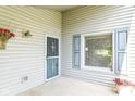 Covered porch featuring a storm door with decorative details, a window with shutters, and neutral siding at 8713 Champions Dr, Indianapolis, IN 46256