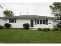 Charming single-story home featuring white siding, blue shutters and door, and a well-maintained lawn at 1021 Harney Dr, Lebanon, IN 46052