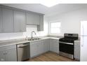Kitchen featuring gray cabinets, stainless steel appliances, granite countertops, and wood look floors at 1021 Harney Dr, Lebanon, IN 46052