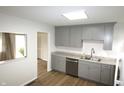 Bright kitchen with gray cabinetry, stainless steel appliances, and wood-look flooring at 1021 Harney Dr, Lebanon, IN 46052