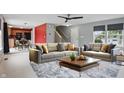 Bright living room with modern sofas, ceiling fan, and stylish rug adjacent to a kitchen with stainless appliances at 10722 Landsbrook N Run, Noblesville, IN 46060