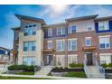 Modern townhouse featuring a combination of brick and stone facade, complemented by well-manicured landscaping at 13050 Grand Vue Dr, Carmel, IN 46032