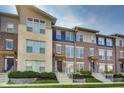 Modern townhouse featuring a combination of brick and stone facade, complemented by well-manicured landscaping at 13050 Grand Vue Dr, Carmel, IN 46032