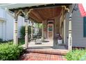 Inviting covered porch features a cozy seating area and brick pathway to the house entrance at 1352 Clinton St, Noblesville, IN 46060
