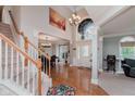 Bright foyer featuring hardwood floors, a staircase, and a large window offering plenty of natural light at 13693 Cunningham Dr, Carmel, IN 46074