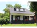 Cute home featuring a covered front porch with brick supports and dormer windows at 1619 Kessler Blvd E Dr, Indianapolis, IN 46220