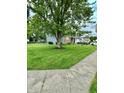 View of the home showing the large front yard with a beautiful tree and established lawn at 1831 Beckenbauer Ln, Indianapolis, IN 46214