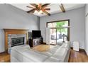 Spacious living room with hardwood floors, fireplace, ceiling fan, and access to the deck at 1850 Longest Dr, Franklin, IN 46131
