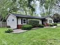 An exterior view of a single-story house with a well-maintained lawn and beautiful garden at 1917 W Norwood Dr, Muncie, IN 47304