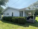 Cozy one-story home featuring a covered porch, neat landscaping, and light blue siding at 2133 10Th St, Columbus, IN 47201