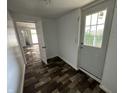 Hallway featuring faux wood floor, white walls, and a white door at the end at 2310 E Raymond St, Indianapolis, IN 46203