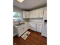 Modern kitchen with white cabinets, sleek countertops, stainless steel sink, and hardwood floors at 233 N 16Th Ave, Beech Grove, IN 46107