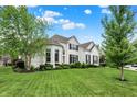 Charming white brick home with a well-manicured lawn, lush trees, and beautifully landscaped front yard at 2535 Dawn Ridge Dr, Westfield, IN 46074