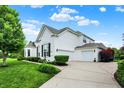 Side view of a white brick home showcasing a well-maintained yard and a spacious three-car garage at 2535 Dawn Ridge Dr, Westfield, IN 46074