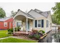 Inviting home with a covered front porch, Adirondack chairs, landscaped garden, and a light blue front door at 28 N Elizabeth St, Indianapolis, IN 46219