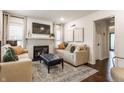Comfortable living room featuring a fireplace, neutral-toned sofas, ottoman, and hardwood floors at 28 N Elizabeth St, Indianapolis, IN 46219