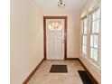 Cozy foyer featuring tile floors, a white front door and a large window to the left at 341 Barton Ave, Indianapolis, IN 46241