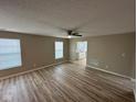 Bright living room with a ceiling fan, fresh paint, laminate flooring, and lots of natural light at 3861 Candle Berry Dr, Indianapolis, IN 46235