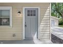 Close-up of the front door, highlighting its glass-paneled design and classic style, complemented by neutral siding and an outdoor light at 420 Vista Dr, Carmel, IN 46280