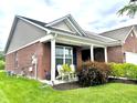 Well-kept red brick home featuring an inviting front porch with chairs at 4209 Switchgrass Way, Indianapolis, IN 46237