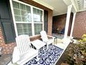 Welcoming front porch with white Adirondack chairs and a stylish blue rug at 4209 Switchgrass Way, Indianapolis, IN 46237