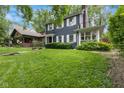 Traditional home with a lush green lawn and mature trees at 519 Woodruff Place Middle Dr, Indianapolis, IN 46201