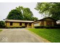 Beautiful single-story home with stone facade and attached garage, surrounded by lush greenery at 5331 Birch Ln, Greenwood, IN 46143